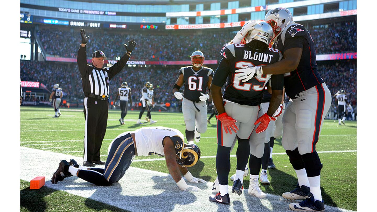 Patriots running back LeGarrette Blount is mobbed by teammates after scoring a touchdown on a 43-yard run against Eugene Sims and the Rams.