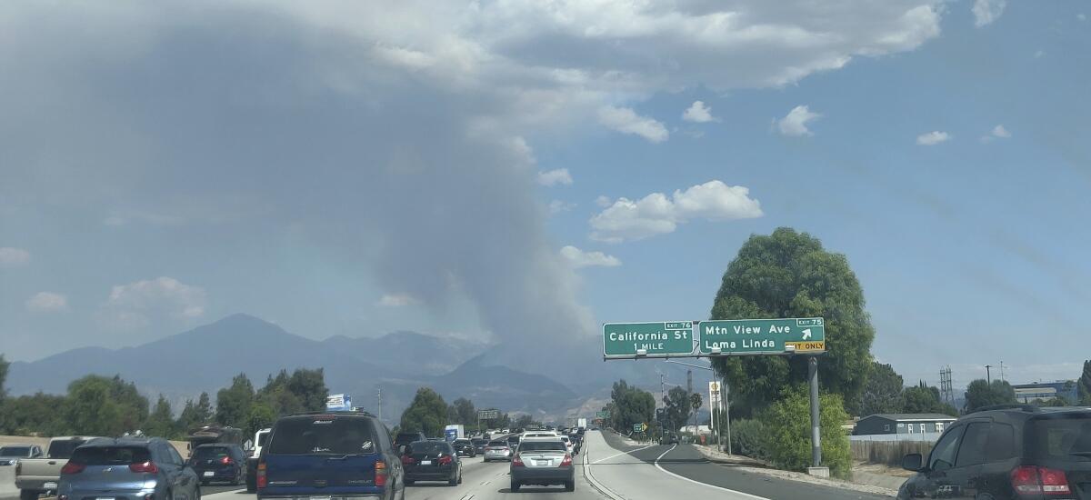 Esta fotografía muestra una columna de humo de un incendio forestal desde la interestatal 10 en Loma Lind