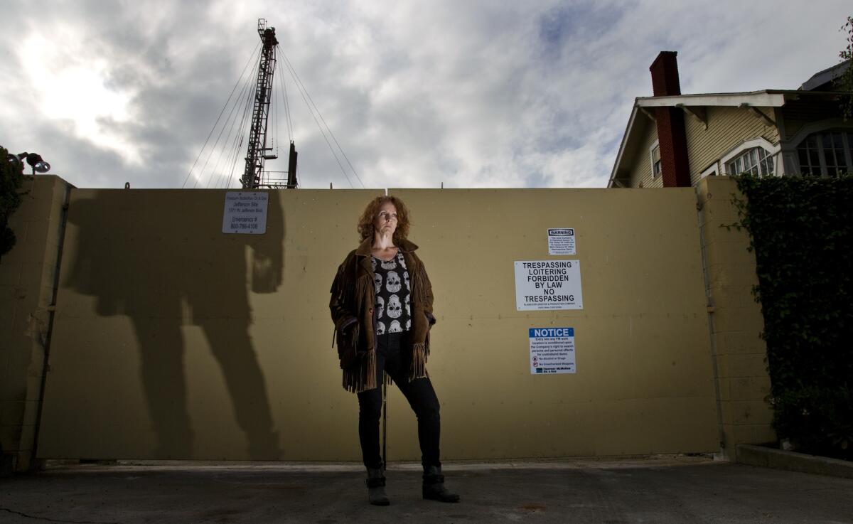 DonnaAnn Ward, founder of Cowatching Oil L.A., stands in front of a drilling site at Jefferson and Budlong Avenues on February 26, 2014 in Los Angeles, California.