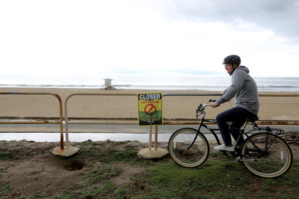 A bicyclist takes a break north of the Huntington Beach Pier on April 10.