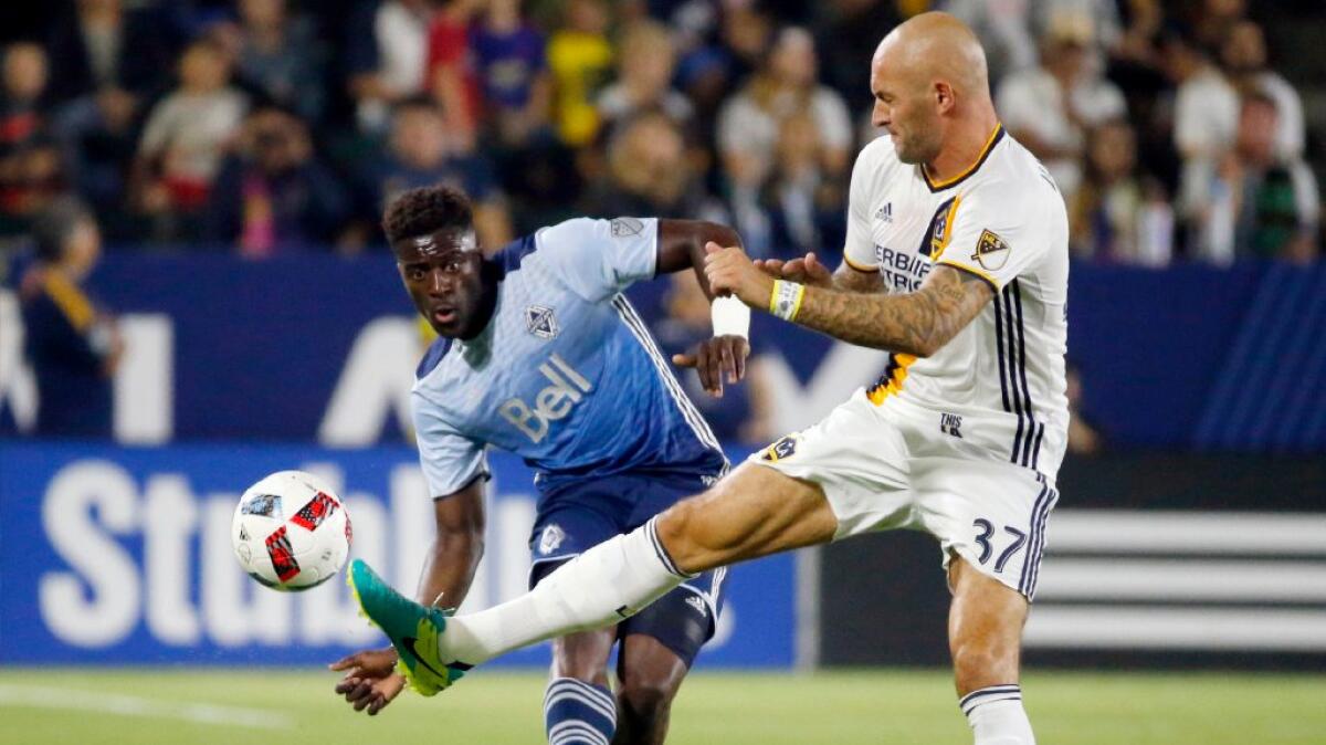 Whitecaps defender Jordan Smith, left, and Galaxy defender Jelle Van Damme vie for the ball during the first half of a game on Aug. 27.