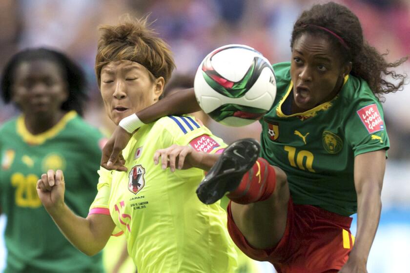 Cameroon's Jeannette Yango, right, jumps for the ball in front of Japan's Yuika Sugasawa during the first half of a FIFA Women's World Cup soccer match on Friday.