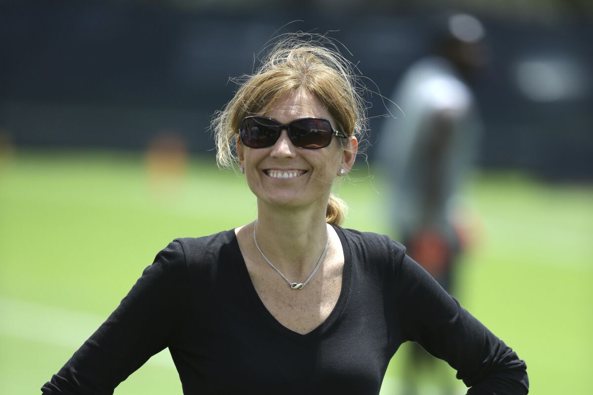 FILE - Then-Miami Dolphins Executive Vice President of Football Administration Dawn Aponte stands on the field after a Miami Dolphins voluntary veterans football minicamp in Davie, Fla., April 26, 2016. Even though the NFL attempted to enhance opportunities for minority candidates to become head coaches in a league whose players are 70% black, there was a disconnect. Same thing for front office positions, although more improvement had been seen in recent years in that area. (AP Photo/Lynne Sladky, File)