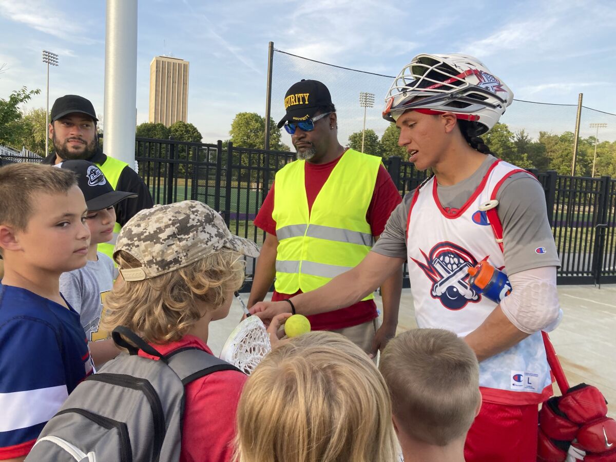 Premier Lacrosse League star Lyle Thompson signs autographs after a scrimmage on May 31, 2022 at Tom & Mary Casey Stadium in Albany, N.Y.. World Lacrosse, the international governing body of the sport, is making a proposal to have the Native American sport included in the 2028 Los Angeles Olympics. Thompson, 29, is from the Onondaga Nation outside Syracuse, N.Y., and starred in college for the Albany Great Danes, setting the national career scoring record and twice winning the Tewaaraton Award given annually to the best male and female college players. Playing in the Olympics would fulfill a dream. (AP Photo/John Kekis)