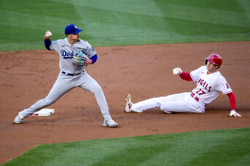 Anaheim, CA - June 21: Dodgers second baseman Miguel Vargas looks to first as Angels starting pitcher Shohei Ohtani is out while sliding into second base on Mike Trout's single at Angel Stadium in Anaheim Wednesday, June 21, 2023. (Allen J. Schaben / Los Angeles Times)