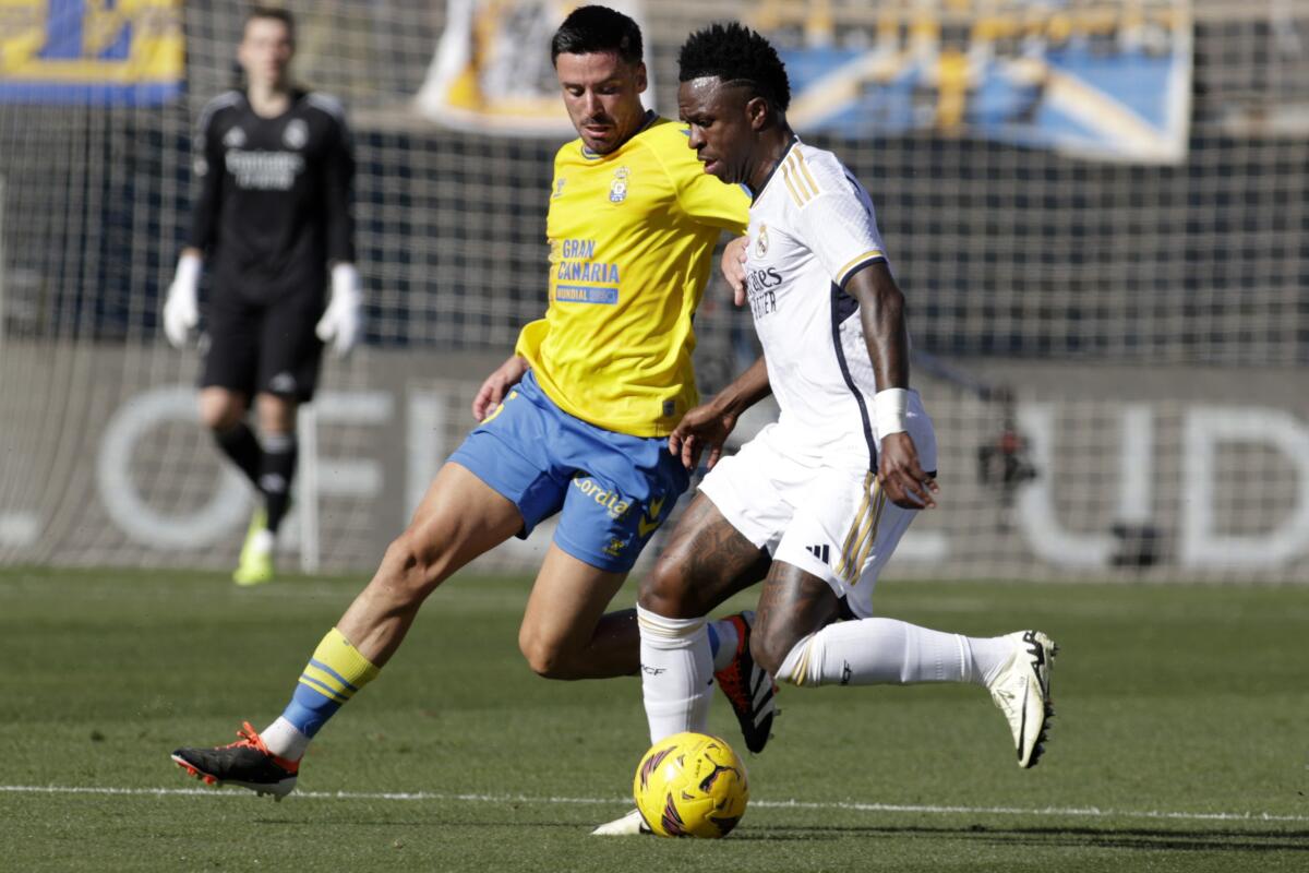 Vinicius Junior del Real Madrid avanza con el balón mientras lo defiende Javi Muñoz de Las Palmas