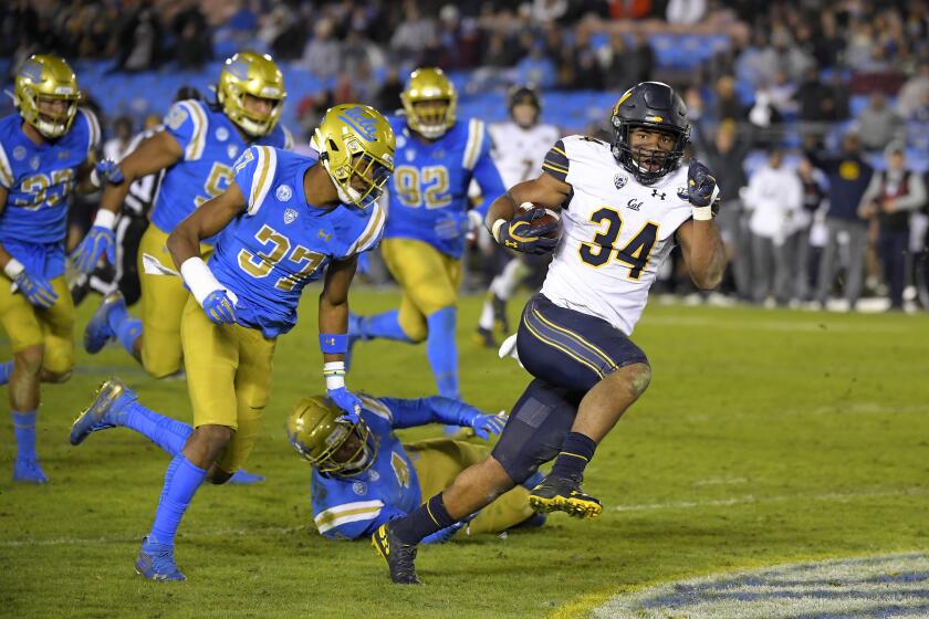 California running back Christopher Brown Jr., right, runs the ball as UCLA defensive back Quentin Lake (37) gives chase along with several other UCLA players during the second half of an NCAA college football game Saturday, Nov. 30, 2019, in Pasadena, Calif. California won 28-18. (AP Photo/Mark J. Terrill)