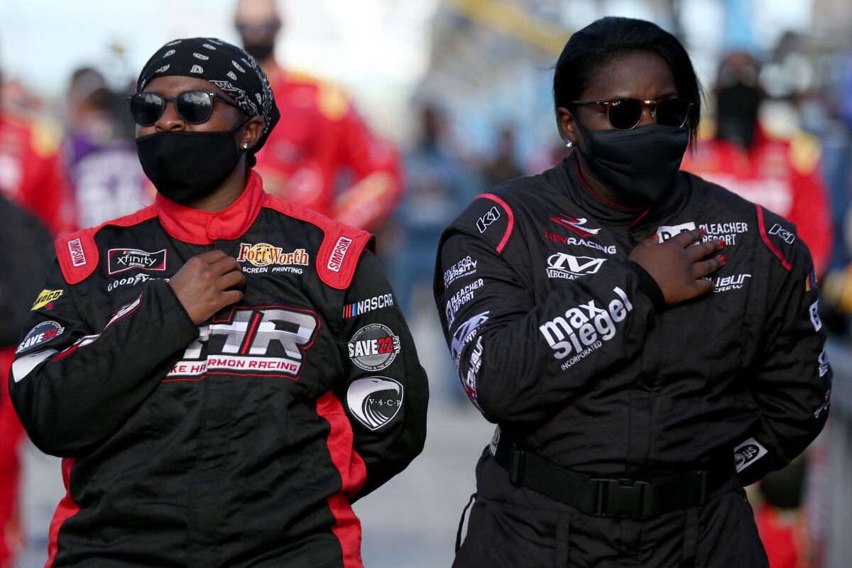 NASCAR pit crew members Brehanna Daniels, left, and Dalanda Ouendeno stand during the national anthem.