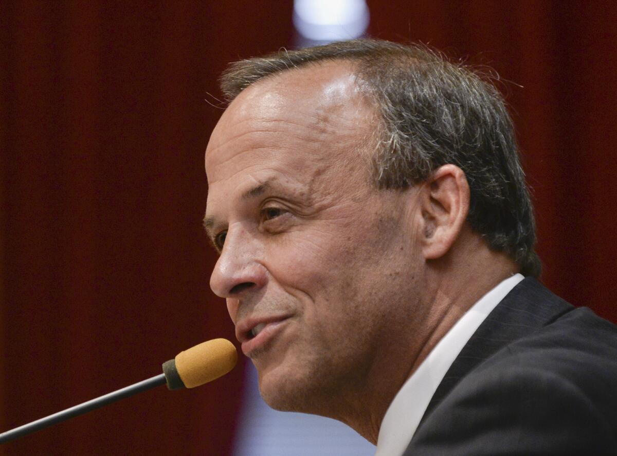 Peoria, Ill. Mayor Jim Ardis addresses a City Council meeting in 2013. Police officers trying to find out who was behind a fake Twitter account set up in the name of Peoria's mayor raided a home Tuesday, seizing computers and phones, and questioning several people.