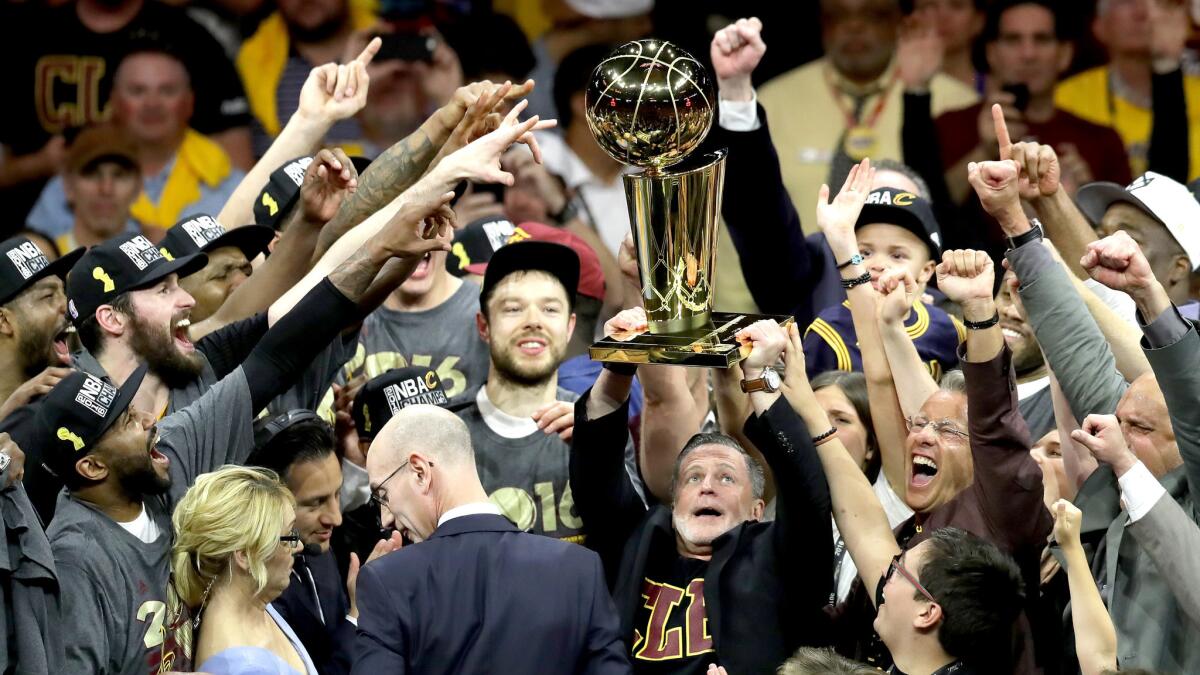 Cleveland Cavaliers owner Dan Gilbert hoists the Larry O'Brien trophy.