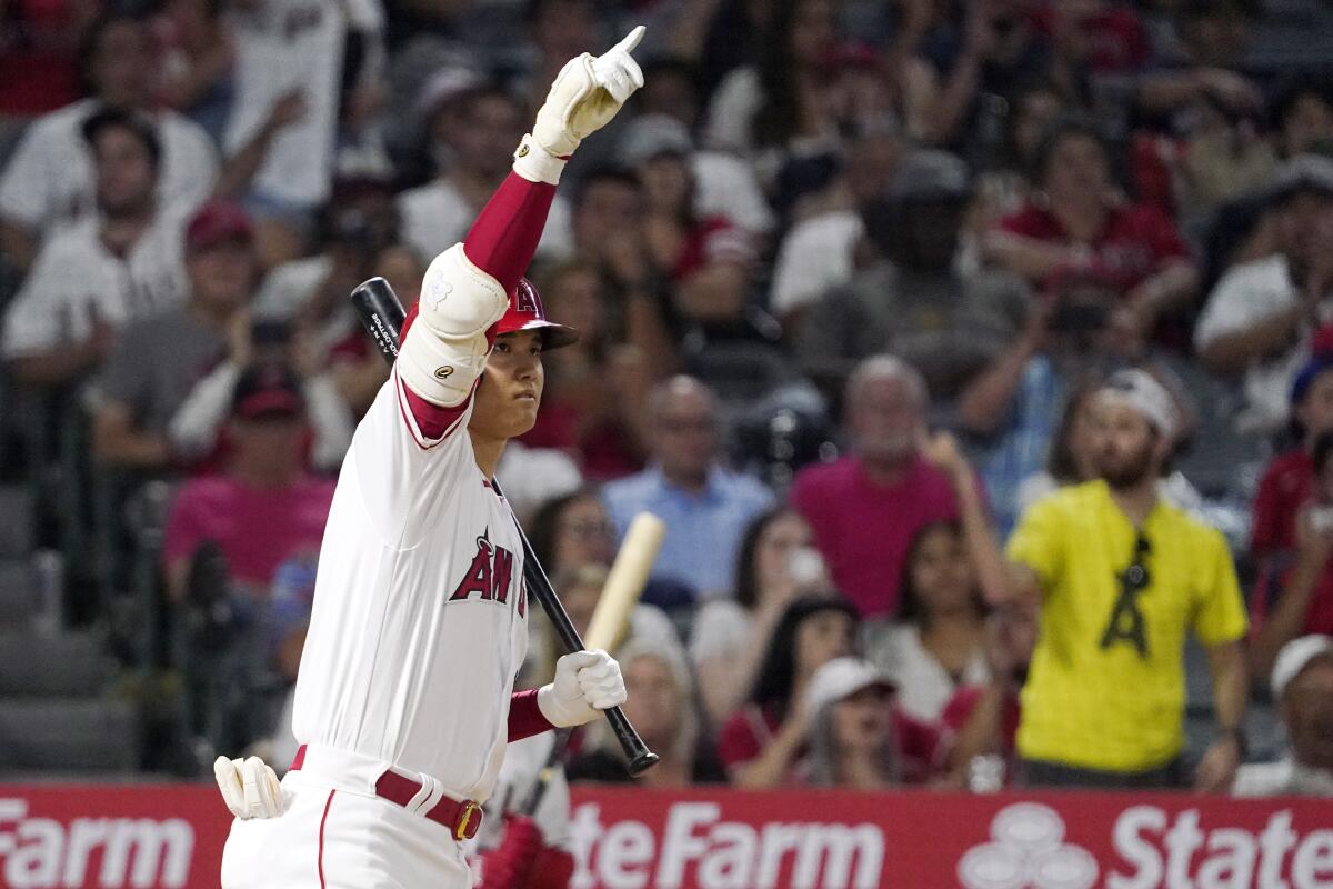 The Angels' Shohei Ohtani gestures to David Fletcher as Fletcher advances to second on a wild pitch during the eighth inning.