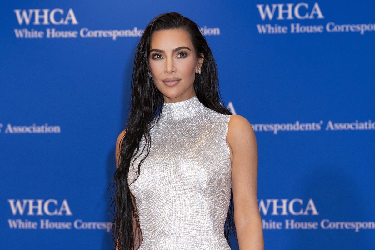 A woman in a sparkly silver dress arrives at an event