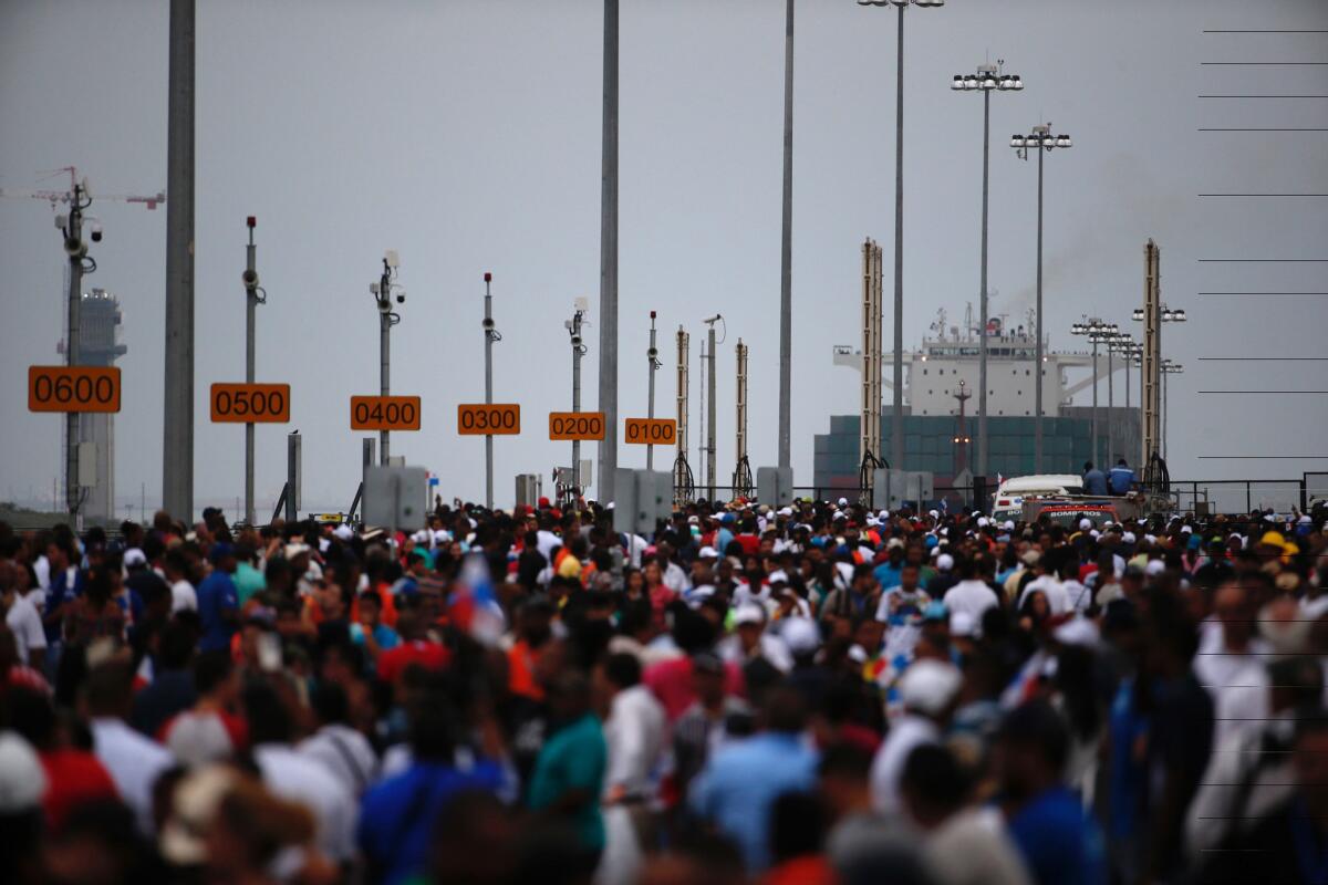Miles de espectadores observan mientras el portacontenedores chino "Cosco Shipping Panama" se prepara para cruzar la nueva esclusa de Agua Clara, parte del ampliado Canal de Panamá, cerca de la ciudad portuaria de Colón, Panamá, la mañana del domingo 26 de junio de 2016. (AP Foto/Moisés Castillo)