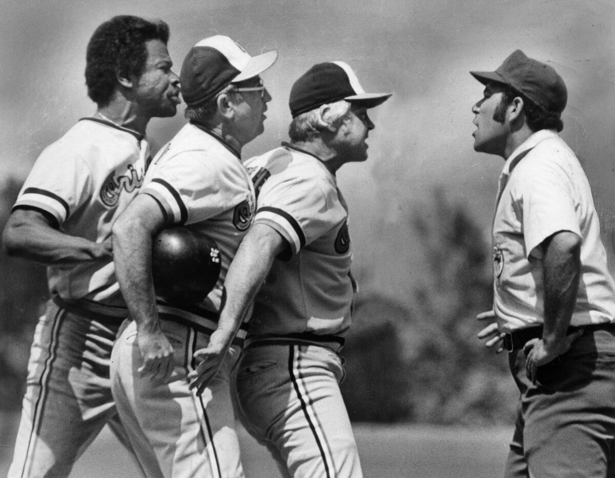 July 11, 1976: Baltimore Orioles line up to voice their opinions to umpire Al Clark, right, after Clark threw Tommy Harper, left, out of a game at Angel Stadium in Anaheim.