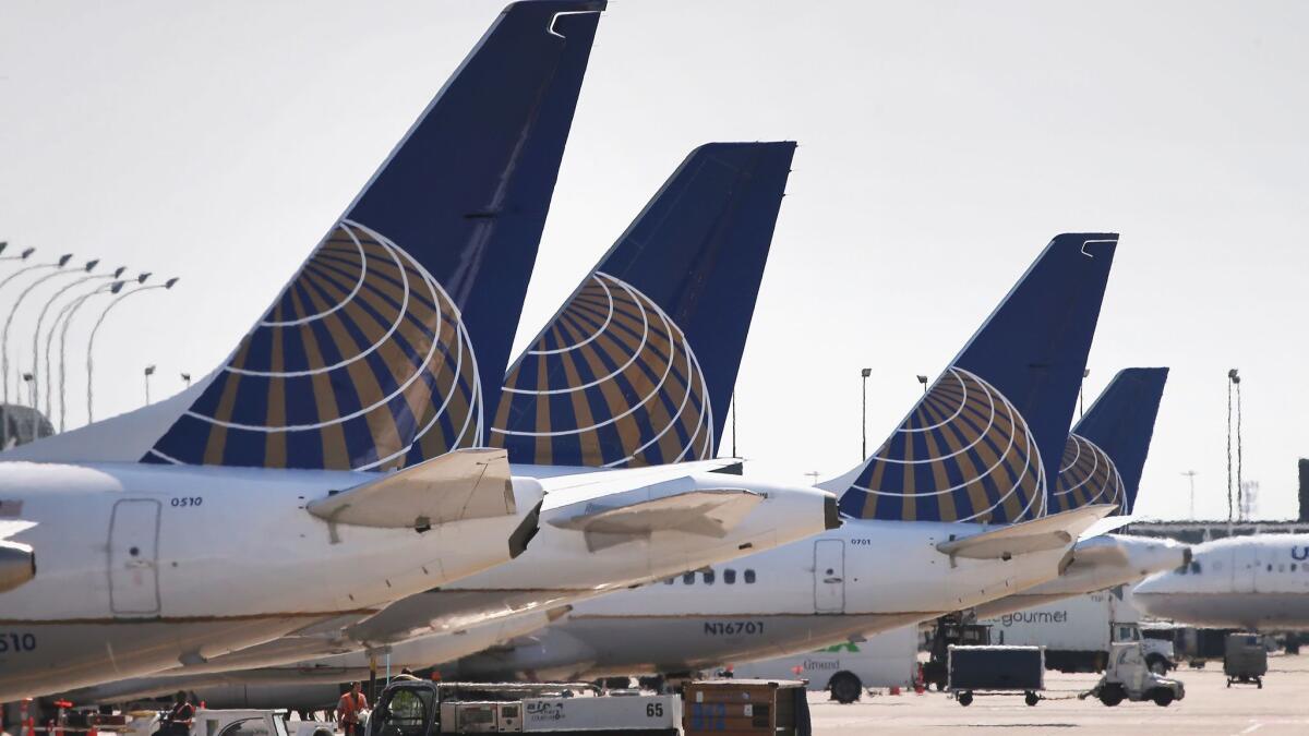United Airlines jets sit at gates at O'Hare International Airport in 2014 in Chicago. A passenger who said she was chosen to give up her seat had asked for cash in return. She settled for the $10,000 voucher.