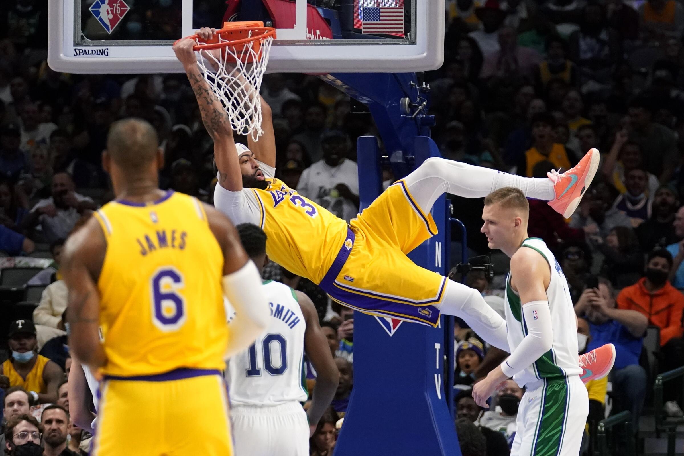 Lakers forward Anthony Davis dunks over the Dallas Mavericks' Dorian Finney-Smith and Kristaps Porzingis.