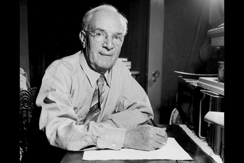 American author Upton Sinclair, writing by the light of his desk at home in California in 1948.