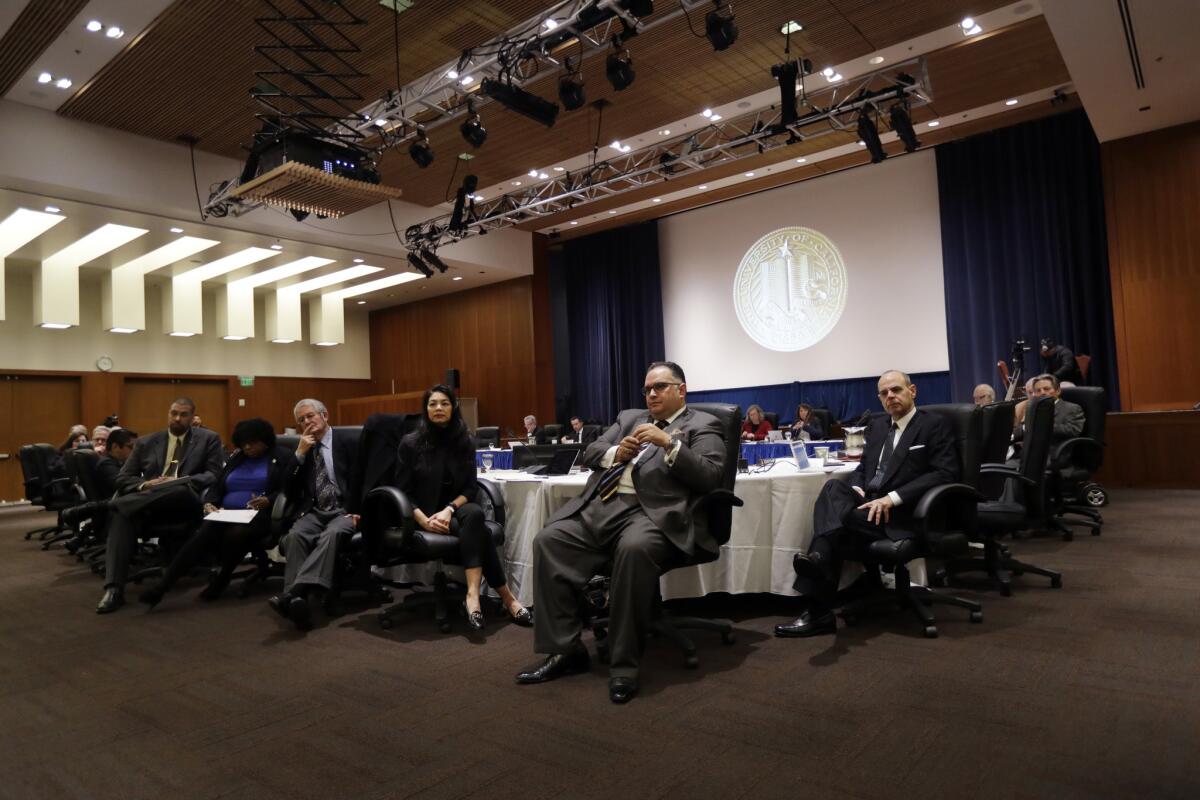 UC Regents gather at tables during a meeting.