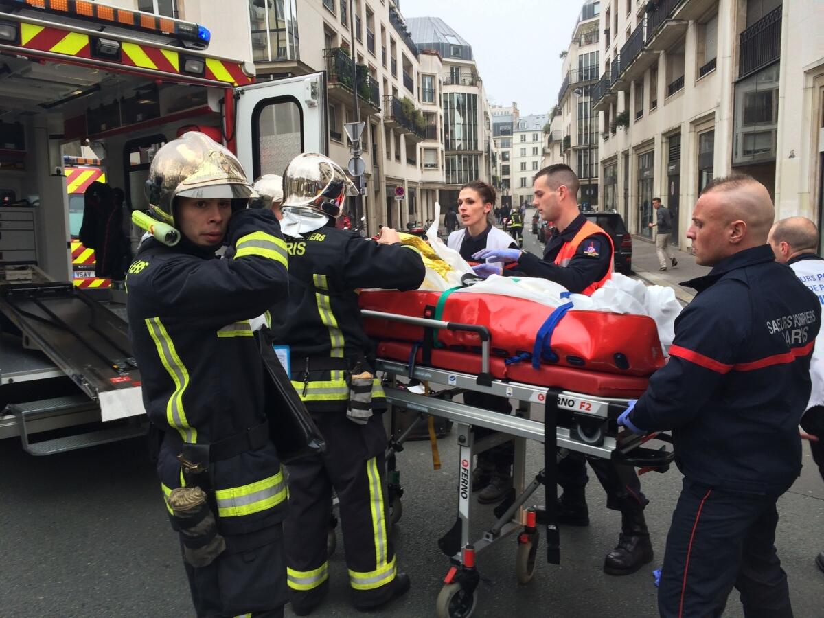 Emergency workers wheel an injured man on a stretcher after the attack on the Paris offices of the French satirical newspaper Charlie Hebdo on Jan. 7.