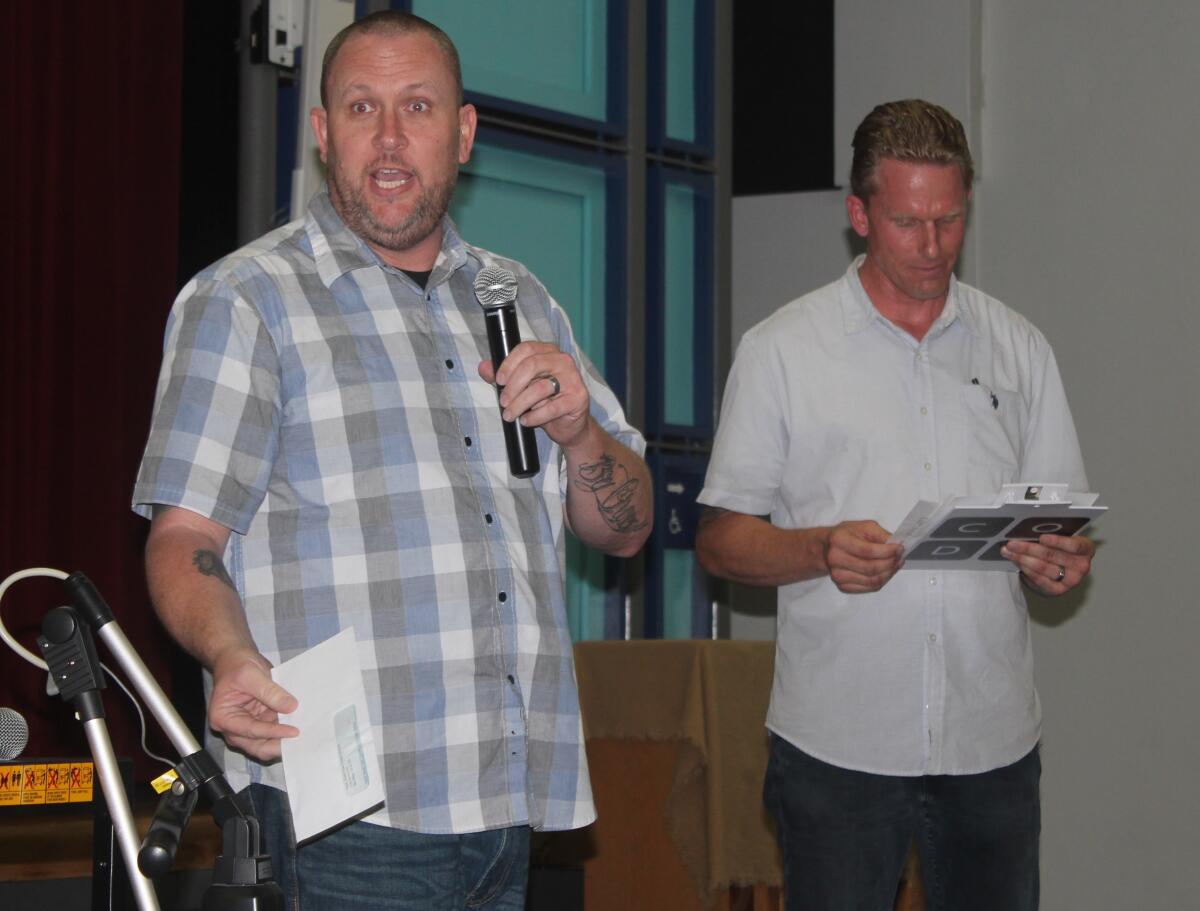 Robert McFaden (left) general manager of The Patio on Lamont, has a $2,500 check for Town Council president Brian White (right) to help sponsor this summer’s Concerts on the Green at Kate Sessions Park.