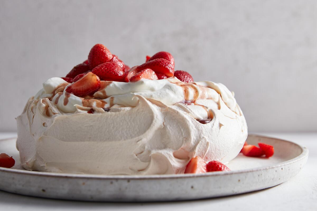 A Pavlova meringue dessert with cream and strawberries.