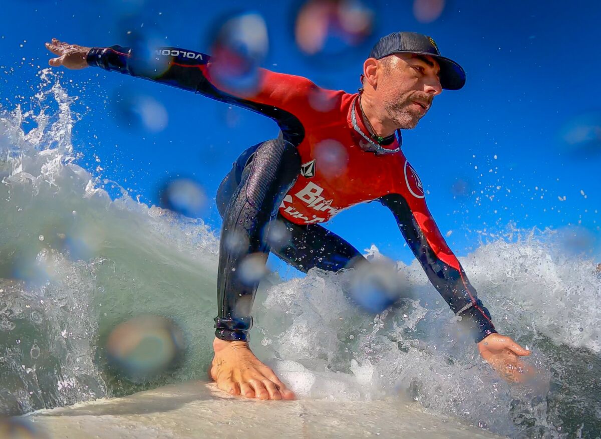 Pete Gustin catches a wave while out surfing in Carlsbad