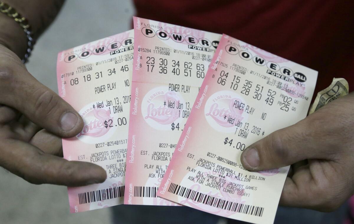A customer shows his purchased Powerball tickets at a grocery store in Hialeah, Fla., on Jan. 11.