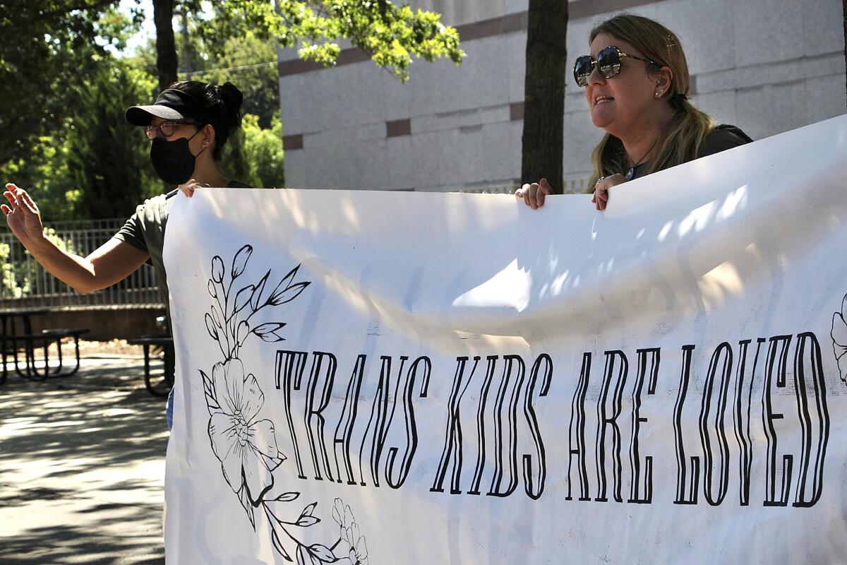 Protesters holding banner in support of transgender youth