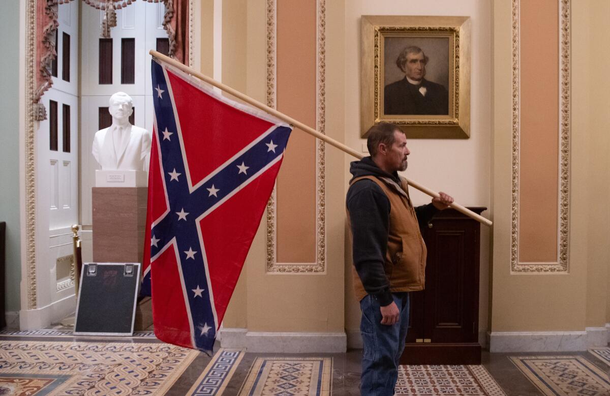 A supporter of Donald Trump holds a Confederate flag inside the U.S. Capitol on Jan. 6, 2021.