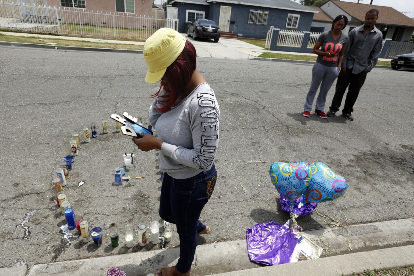 Relatives of Andre McMihelk mourn at a memorial left in his honor along South Nestor Avenue in Compton. McMihelk was shot and killed while walking to a friend's house for a gathering on May 14.