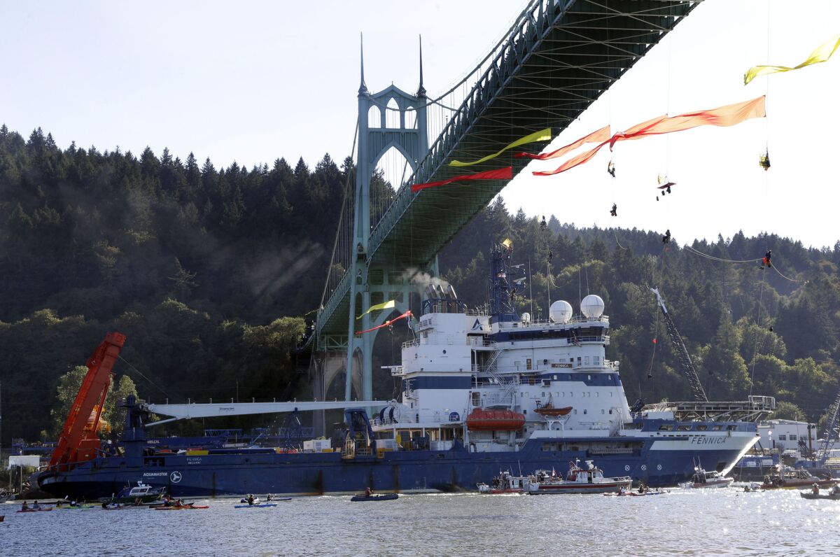 The Shell icebreaker MSV Fennica heads up the Willamette River in Portland, Ore., last month under Greenpeace activists hanging from a bridge.