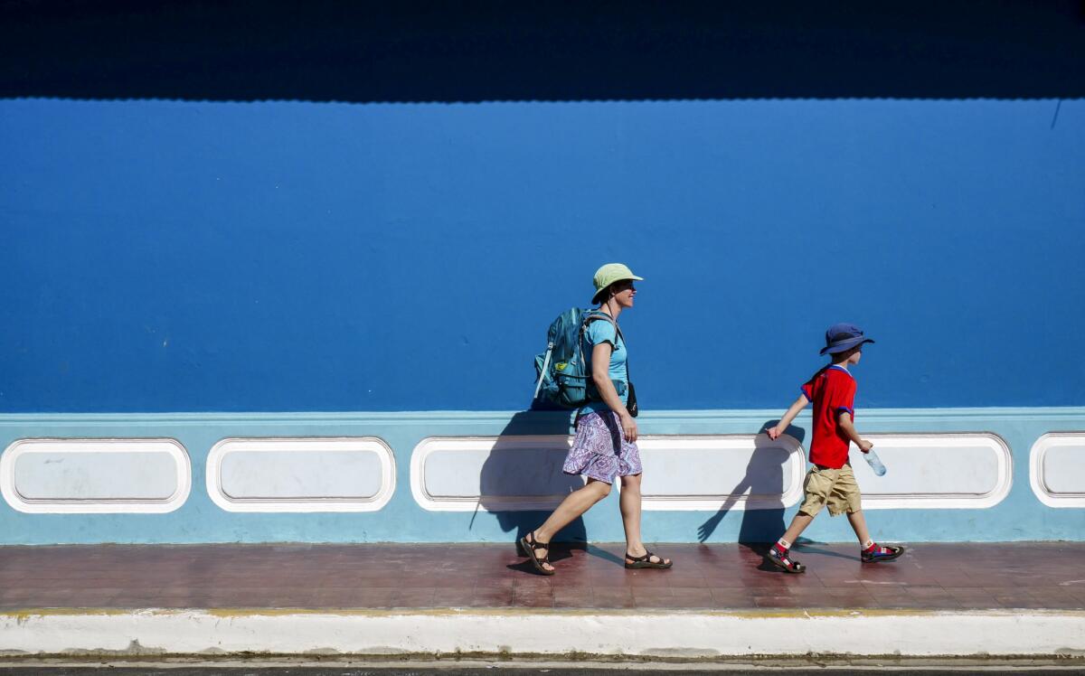 Katie Quirk and son Liam hurry past one of Granada's many bright facades in search of shade. (Tim Waring)