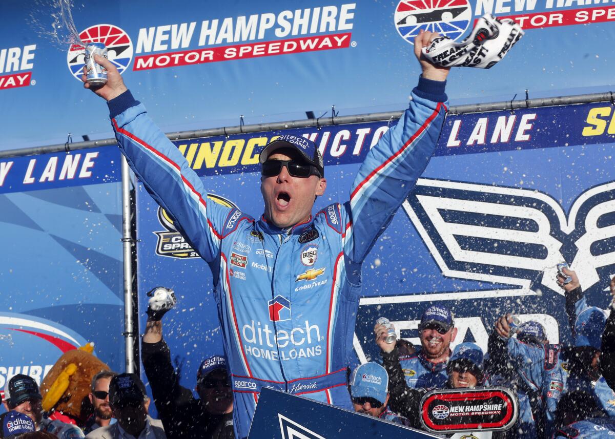 Kevin Harvick celebrates in victory lane after winning the NASCAR Sprint Cup Series race at New Hampshire Motor Speedway.