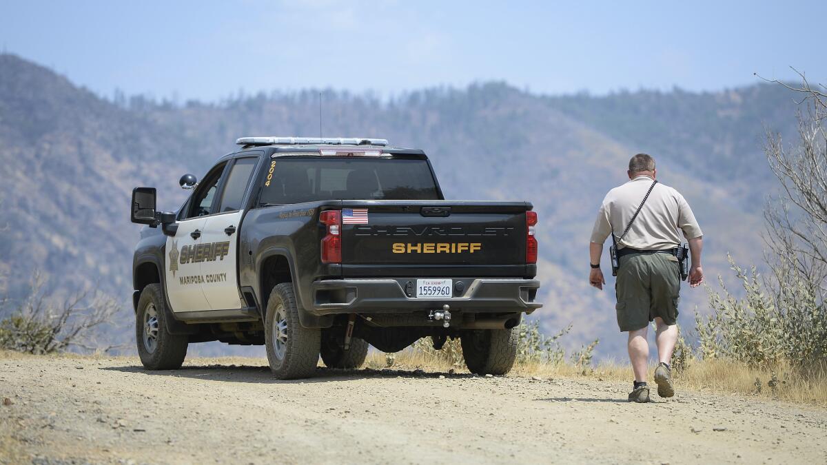 A deputy walks next to a sheriff's truck