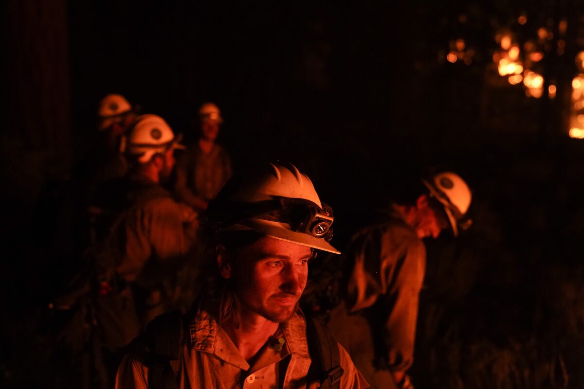 Firefighters take a break while setting a backfire in an attempt to prevent the Caldor Fire from spreading near South Lake Tahoe, Calif., Wednesday, Sept. 1, 2021. (AP Photo/Jae C. Hong)