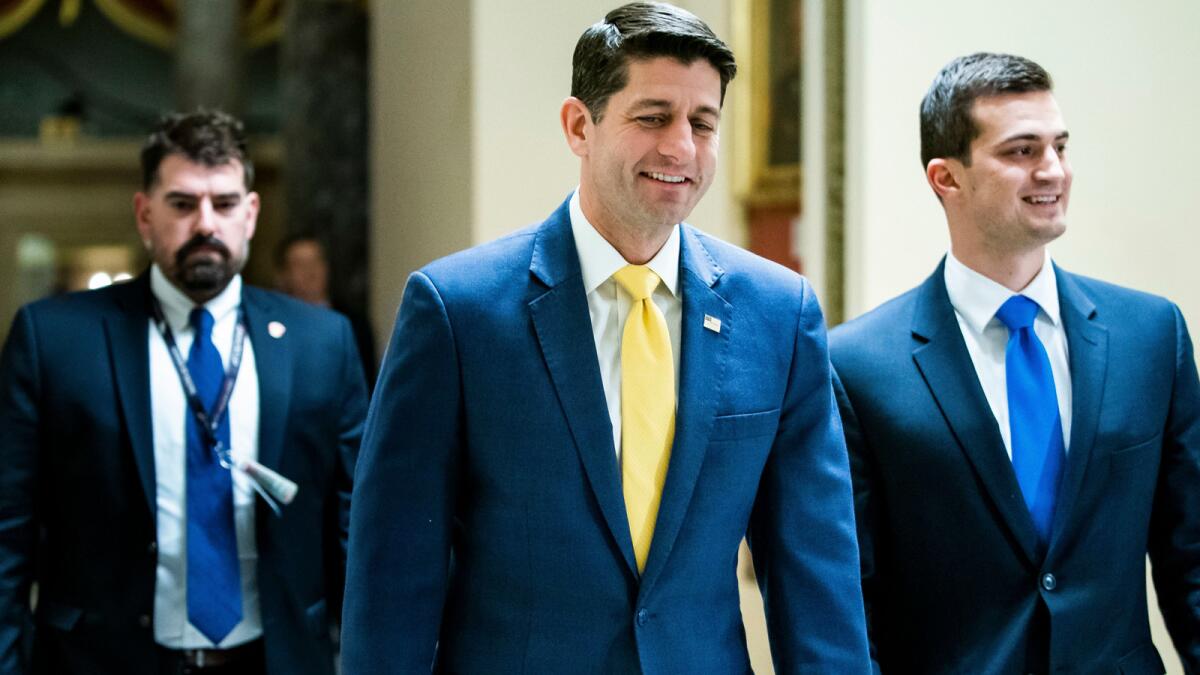 House Speaker Paul D. Ryan, center, walks to the House floor, where lawmakers passed a budget resolution that included border wall funding.