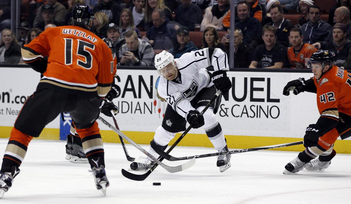 Los Angeles Kings center Trevor Lewis (22) battles to get the puck before Anaheim Ducks center Ryan Getzlaf (15) and defenseman Josh Manson (42) during the first period on Sunday.