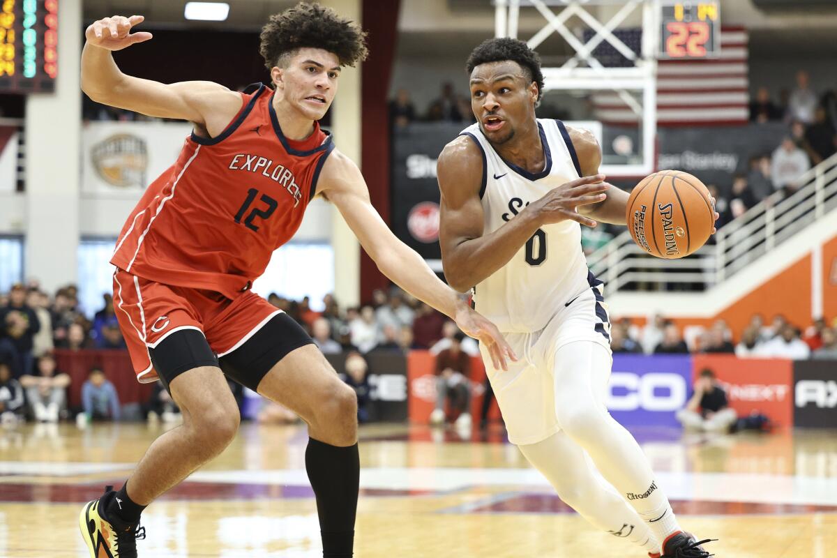 Sierra Canyon guard Bronny James drives against a Miami  (Fla.) Columbus forward Cameron Boozer.