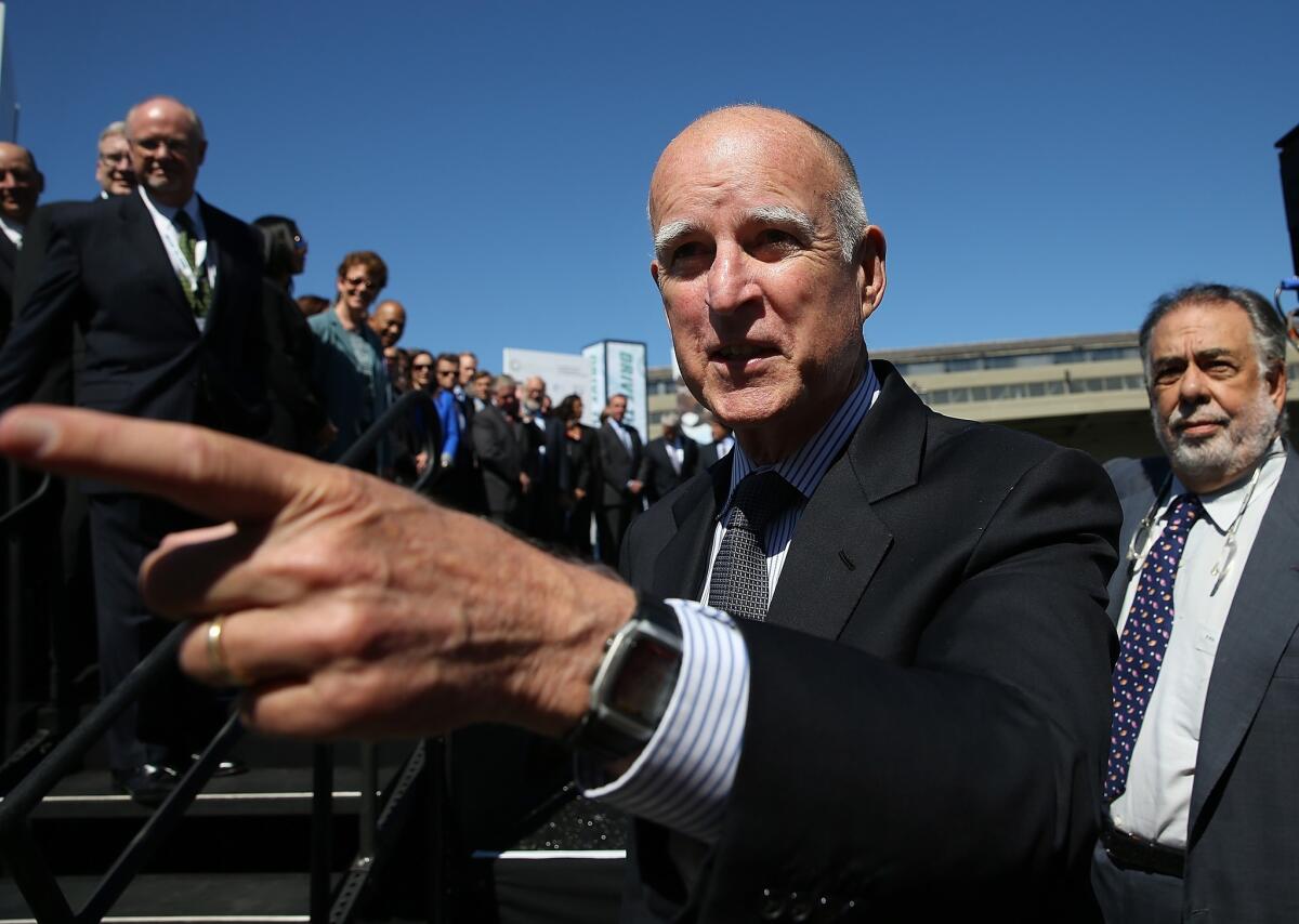Gov. Jerry Brown, pictured here at an event involving electric cars, has to decide which gun control bills to sign.