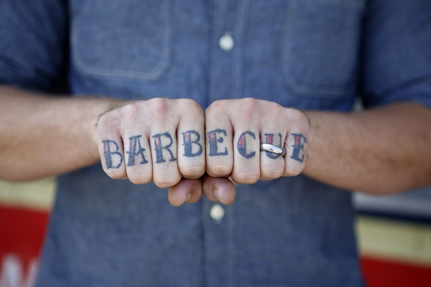 It's on the menu -- and his fingers too: Chef Ryan Lamon shows off his tattoo in front of Peaches' food truck.