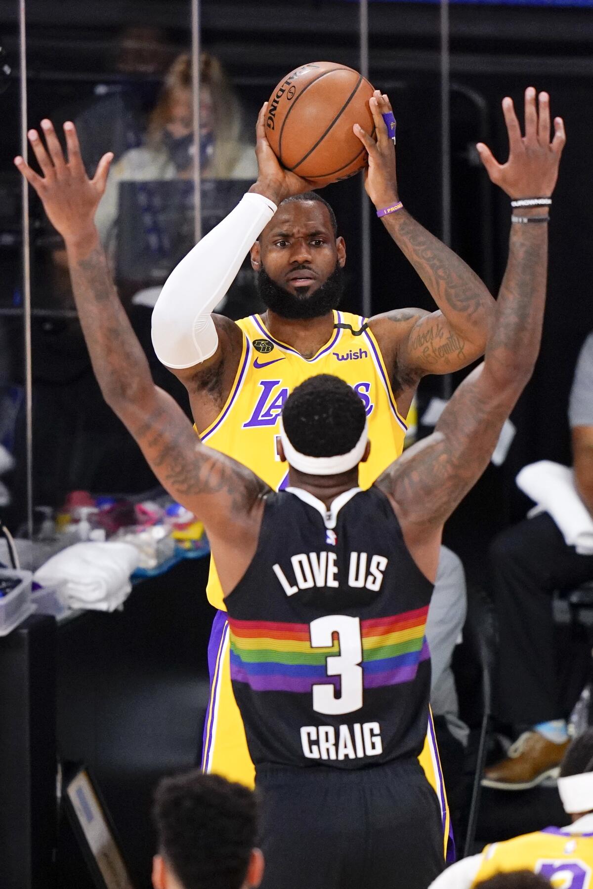 Lakers forward LeBron James looks to pass against the defense of Nuggets forward Torrey Craig during Game 4.