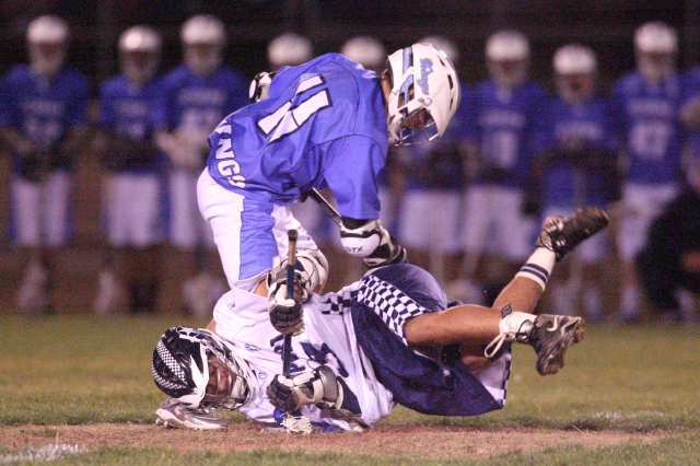 Newport Harbor's Brice Viloria, bottom, hits the ground while battling for possession Corona del Mar's Taylor Epp during the Battle of the Bay lacrosse match at Newport Harbor High School on Friday.