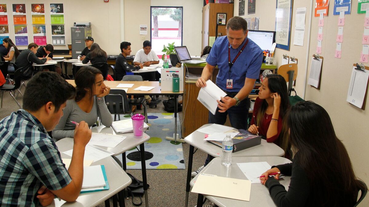 In a Personalized Learning Academy classroom at Vista High School, teacher Jeb Dickerson (standing) works with students in a history class in Vista, California.