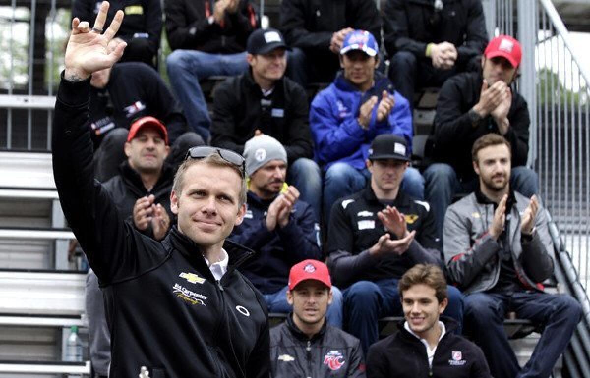 Pole-sitter Ed Carpenter waves to fans as he's introduced during the public drivers meeting for the Indianapolis 500 on Sunday morning.