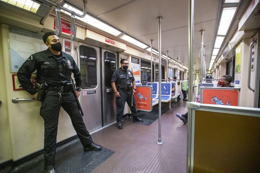 HOLLYWOOD, CA - JUNE 25: LAPD officers E. Rosales, left, and D. Castro, patrol the Metro Red Line at the Hollywood/Highland Metro Station Thursday, June 25, 2020 in Hollywood, CA. The Metro Board of Directors held a meeting Thursday where the agenda included the consideration of appointing a committee to develop plans for replacing armed transit safety officers with ``smarter and more effective methods of providing public safety.'' Metro security is staffed by multiple agencies, including the L.A. County Sheriff's Department and L.A. and Long Beach police departments, transit security guards and contract security workers. (Allen J. Schaben / Los Angeles Times)