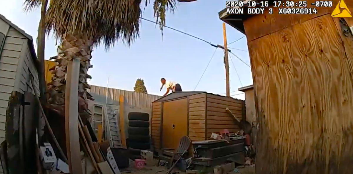 Screen grab from body camera video shows a man jumping over a backyard fence