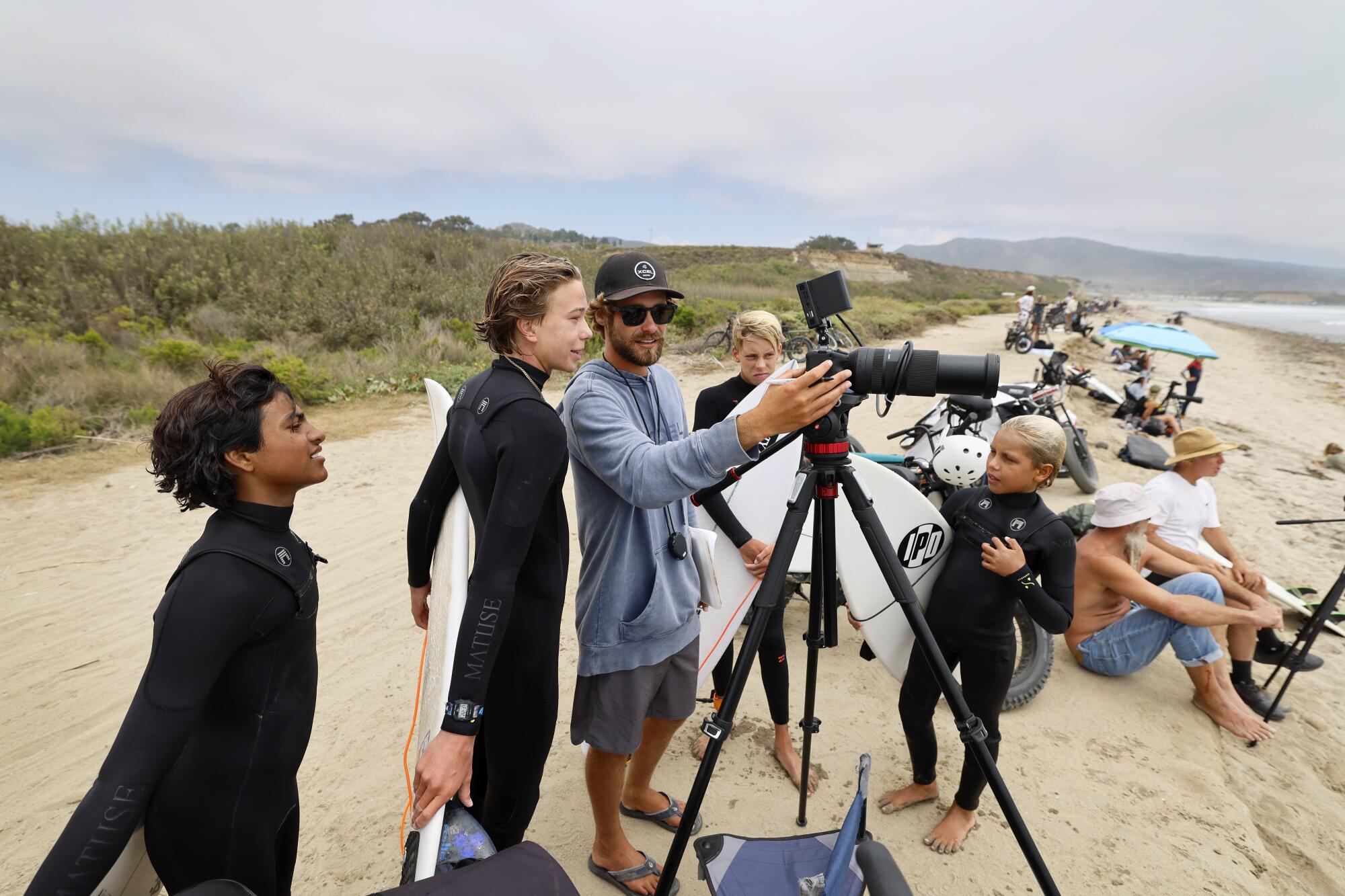Surf instructor Lucas Taub, center, reviews performance videos with young surfers in San Clemente.