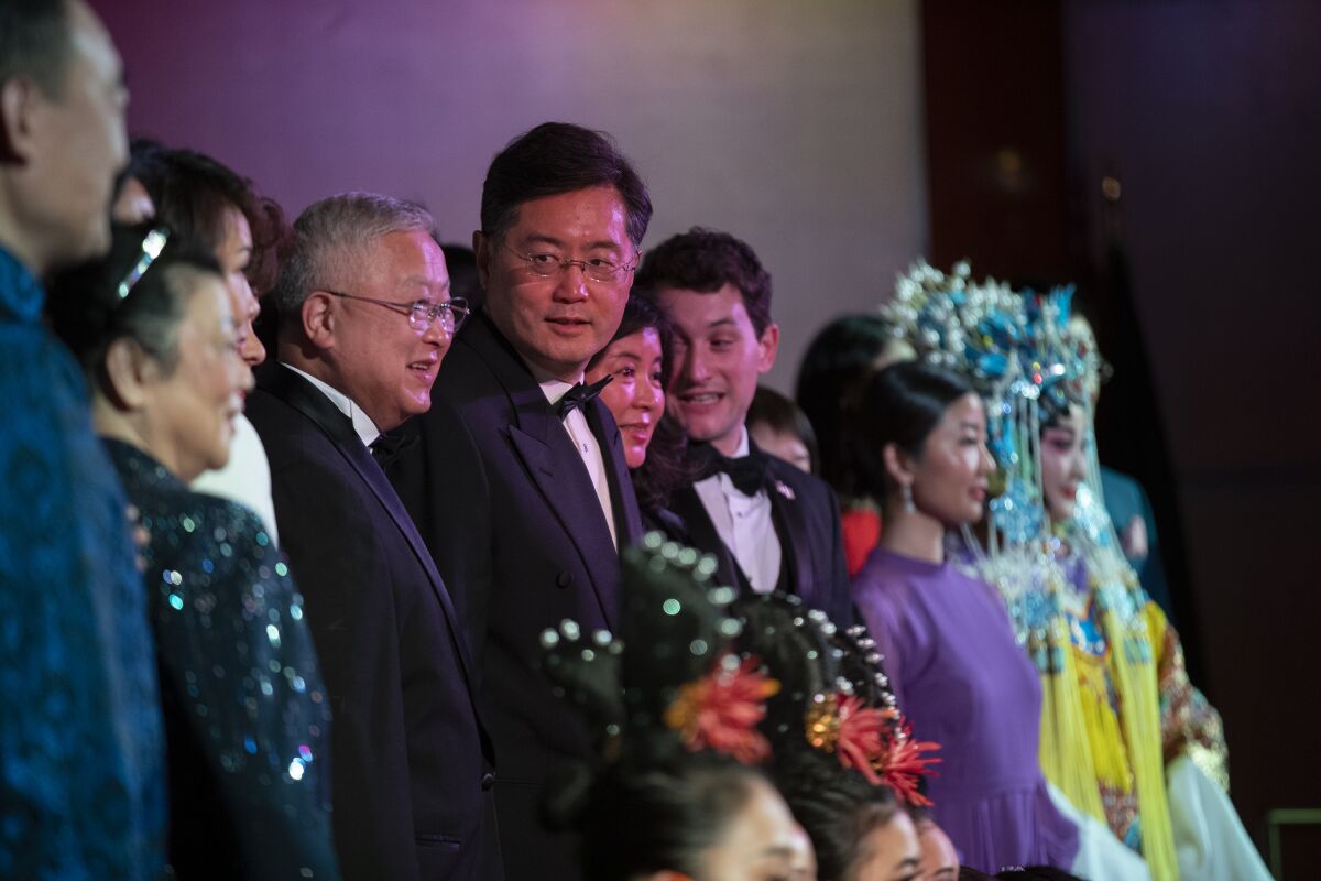 Chinese Ambassador Qin Gang stands in a row with other dignitaries and performers in Chinese cultural outfits