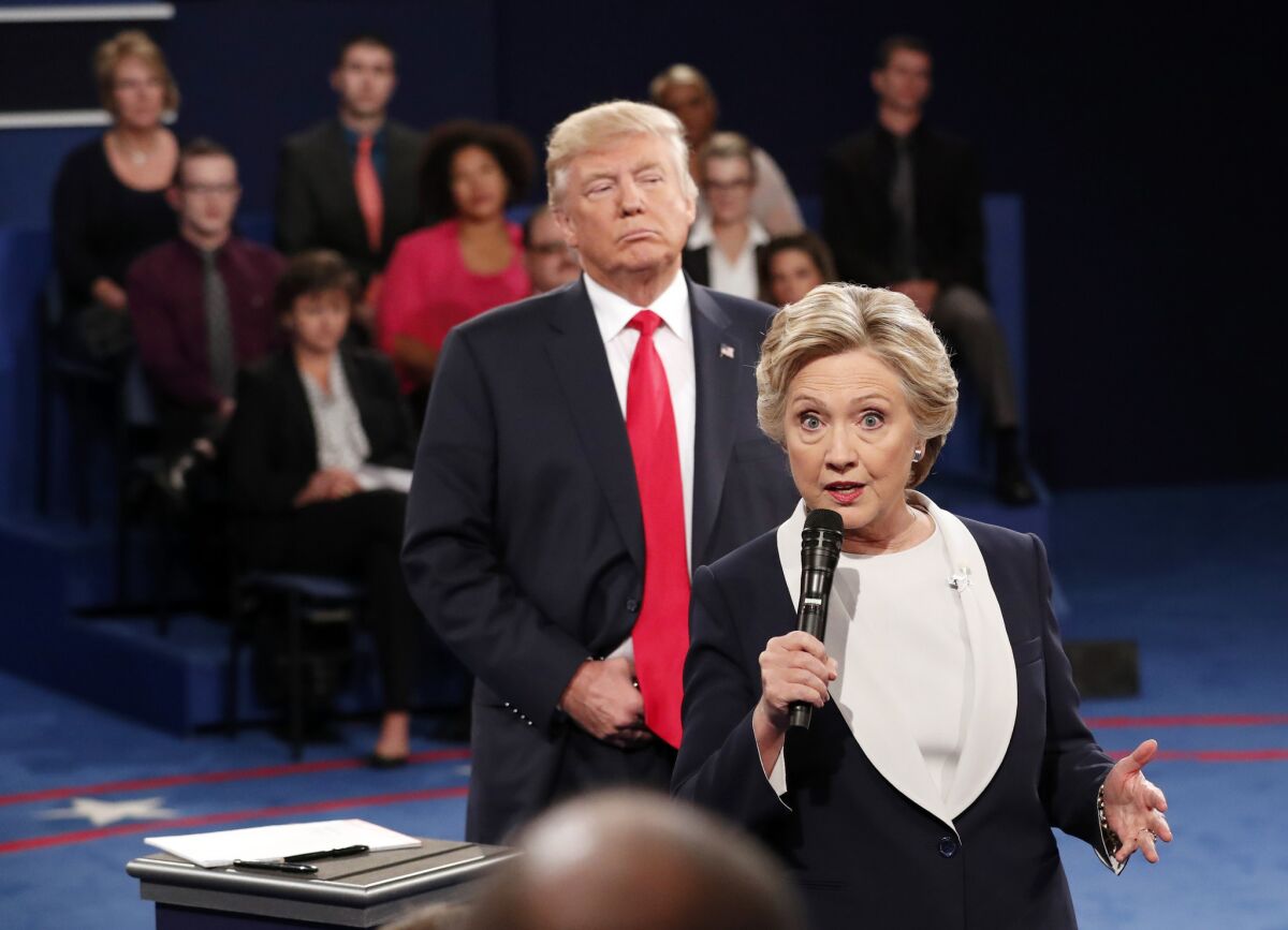 Donald Trump stands behind Hillary Clinton as she speaks during the second presidential debate in St. Louis on Oct. 9, 2016.