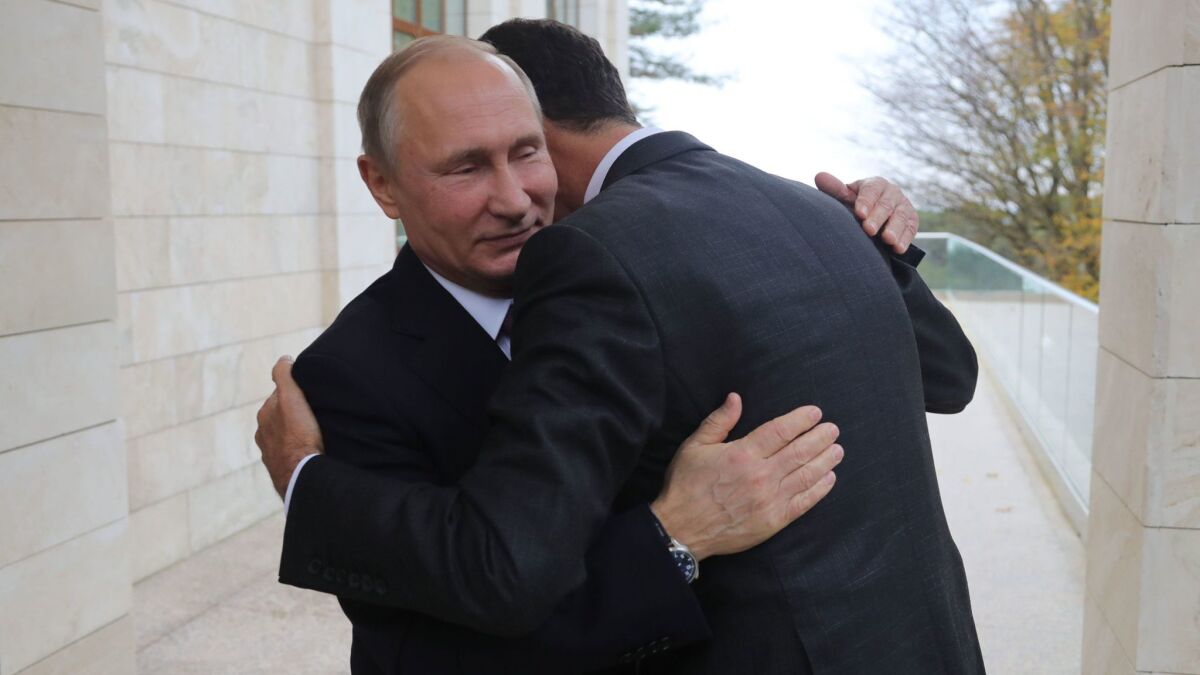 Russia's President Vladimir Putin embraces Syrian counterpart Bashar Assad during a meeting in Sochi, Russia.